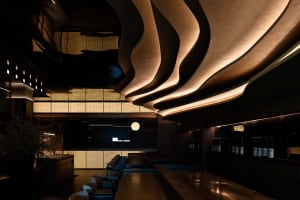 A stylish and contemporary restaurant bar with modern design elements, including glass and concrete materials.