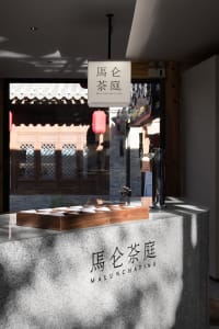 A modern coffee shop featuring a granite and wood counter.