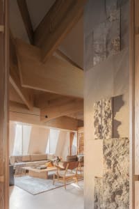 A modern living room with wooden furniture and stone accents