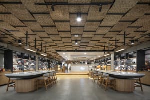 A cozy coffee shop features a unique bamboo ceiling design, providing a comfortable atmosphere for visitors.