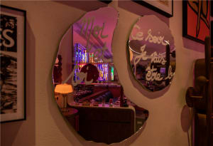A modern restaurant interior with metallic wall art and stained glass windows.