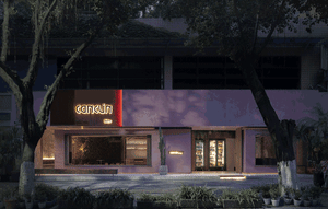 Pink brick storefront with large glass windows and signage.