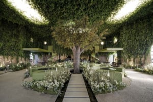 Concrete lobby with greenery, seating, and lighting