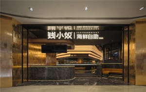 An entrance to a modern restaurant with metallic tiles and marble flooring.