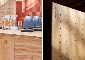 A wooden coffee station with pegboard wall and electric kettles.