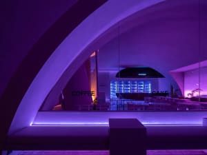 A modern coffee shop with a purple-lit interior designed for relaxation and ambiance