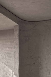 A minimalist architectural design featuring textured concrete surfaces.