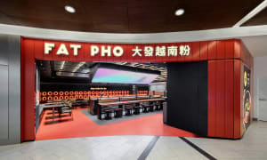 Interior of a modern food court with metal and red color scheme.