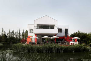 Modern, metallic cafe exterior with a white roof and red facade.