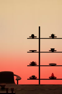 Shelf with decorative items on a wooden table at sunset.
