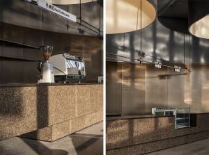 Modern interior of a coffee shop featuring a concrete counter with a coffee machine.