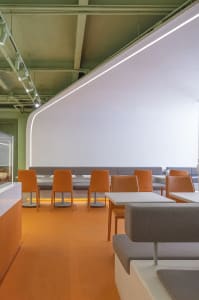 Modern restaurant interior with concrete floating tables and seating