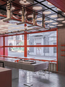 Contemporary restaurant interior featuring a modern, industrial metal counter with stools.