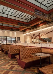 Modern cafe bar interior with leather seating, glass counter, and wooden accents