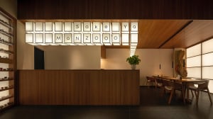 A modern restaurant interior with wooden materials and a sleek, minimalist design.