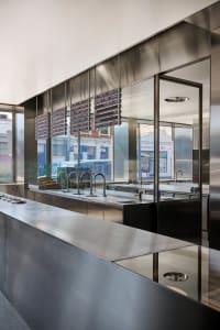 A sleek, modern restaurant counter featuring steel and glass elements