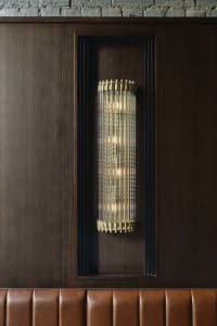 Modern wall lighting fixture with metal and glass elements.