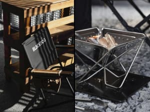 A metal outdoor folding burner with wood being burned inside.