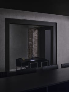 A minimalist black interior with exposed brick wall