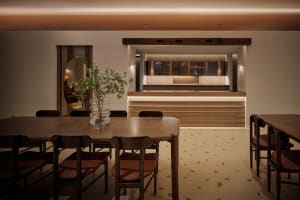 A modern restaurant bar with wooden furniture and warm lighting.