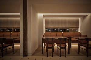 Modern interior design of a restaurant featuring brown leather seating and wooden tables.
