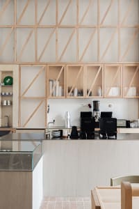 Modern kitchen with transparent wood shelves and sleek white cabinetry.