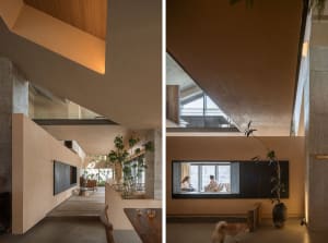 A modern residential space with exposed concrete walls, wooden elements, and large windows, featuring a comfortable seating a