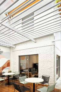 Modern minimalist terrace with white brick walls, concrete flooring, and outdoor seating area.
