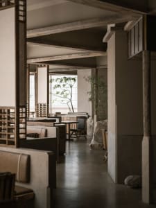 Modern restaurant interior with concrete and wood materials.