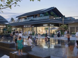 Crowded, modern urban plaza with modern buildings, glass walls, and greenery.