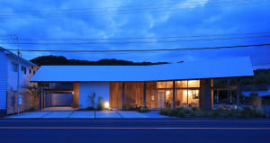 A modern farmhouse with a white exterior and wooden accents, showcasing clean lines and contemporary design elements.