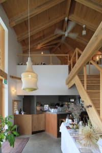 An industrial-style cafe featuring concrete flooring, wooden beams, and a loft interior.