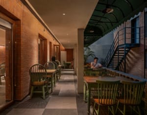 A rustic restaurant interior with exposed brick walls, concrete pillars, and tiled flooring.