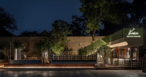 A modern urban restaurant exterior with green accents and concrete details.