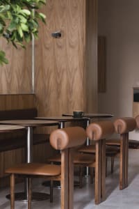 Industrial-style cafe interior featuring wooden furniture and a cup on a table.