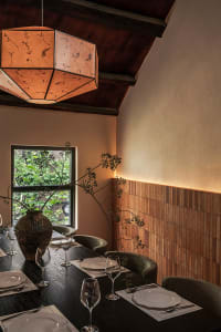 Dining room with wood accent wall, table, chairs, and floral arrangement, showcasing modern design elements.