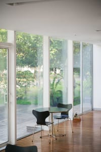 A modern coffee shop with a glass front, featuring a welcoming interior space.