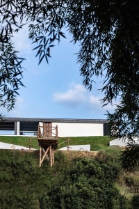 A wooden platform with a structure on a green hillside.