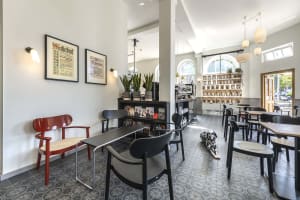 Interior of a minimalist coffee shop with concrete flooring and seating.