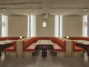 Modern restaurant interior with booth seating made of leather on concrete floor