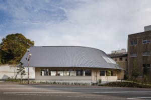 A modern retail storefront featuring a curved metal-clad roof.