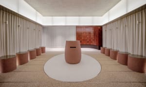 Modern spa bathroom interior with round, terracotta-ceramic feature piece surrounded by white curtains and circular seating a
