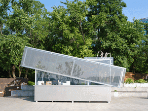 A modern, metal exterior with a geometric design and green trees in the background.