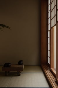 A serene Japanese tea room with a tatami mat floor, minimalist decor, and a window on the right.