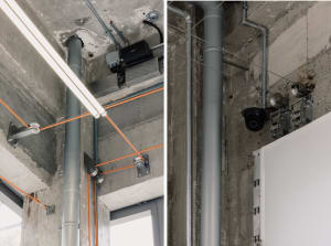 An image showing industrial-style office interior with concrete pipes and cables.
