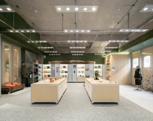 Industrial retail space featuring wooden tables and concrete walls.