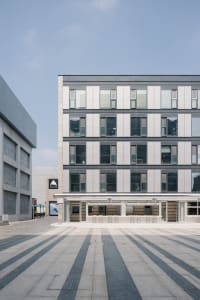 A contemporary modern building constructed with concrete and featuring geometric patterns on its facade and floor.