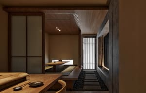 A modern minimalist dining room with wooden flooring and furniture, featuring a wooden table and chairs, and a sliding door.