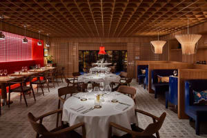 A modern restaurant interior with wooden tables, chairs, and walls.