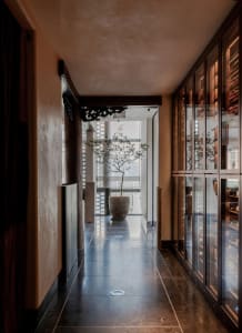 Modern corridor featuring concrete flooring, marble accents, and wooden beams.